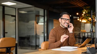 professional man on the phone in front of a laptop